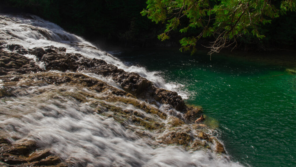 picture with moving water of rocks with emerald green water